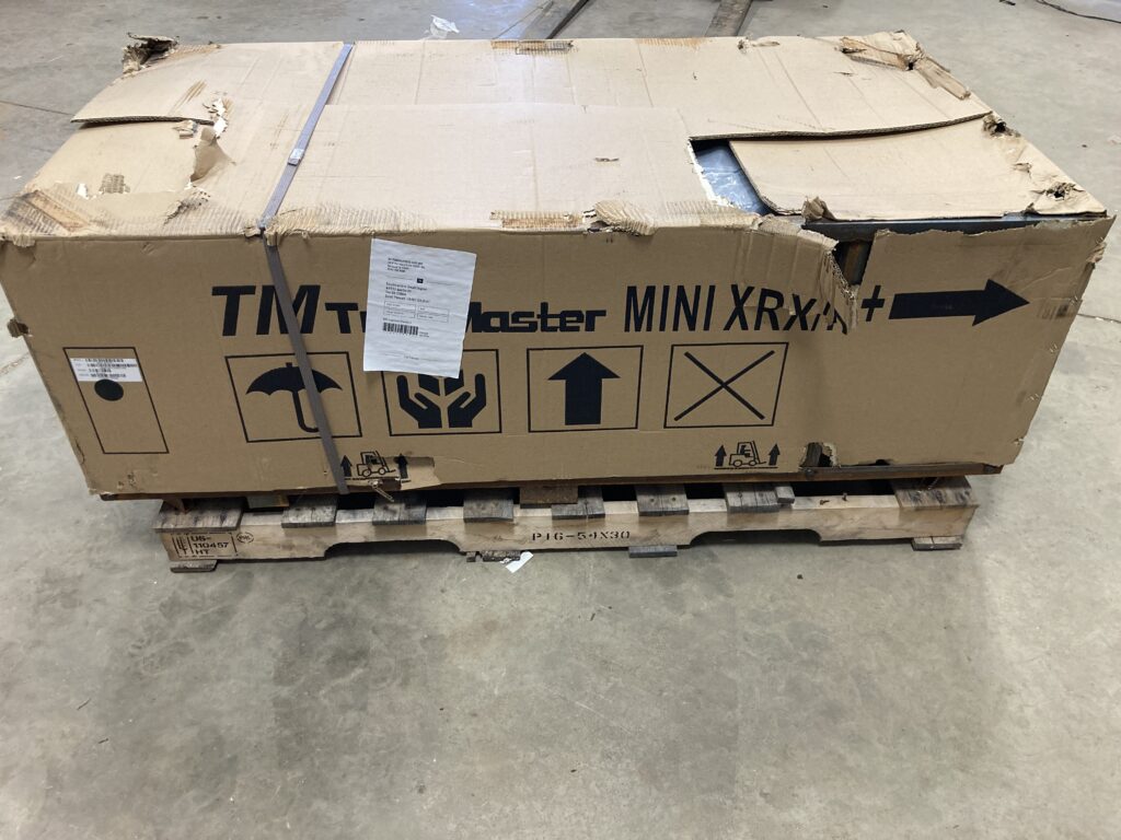 Trailmaster go karts are shipped in a metal crate covered in cardboard